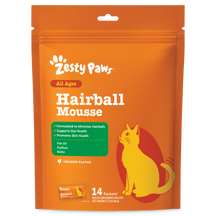 Orange Zesty Paws hairball mousse pouch with yellow cat illustration and green ingredient label, 14 packets.