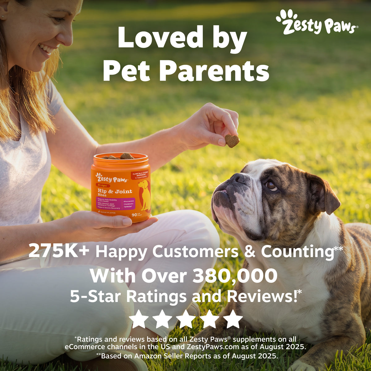 Woman holding orange Zesty Paws Hip & Joint supplement bottle with dog treat in hand while sitting with brown and white bulld