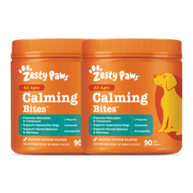 Two orange Zesty Paws Calming Bites containers with peanut butter flavor, featuring a yellow dog illustration and product det