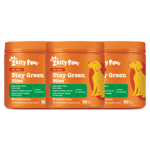 Three orange jars of Zesty Paws Stay Green Bites dog treats with chicken flavor and yellow dog illustration on labels.